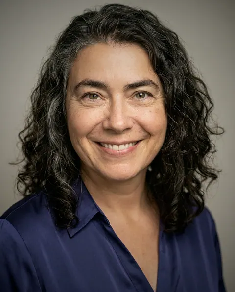 Retrato de Helena Macedo, Diretora de operações do Pollyfriends, sorrindo em fundo cinza claro